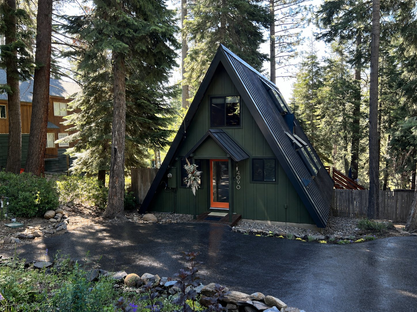 The front of the Tahoe A-Frame in summer, flowers by the door