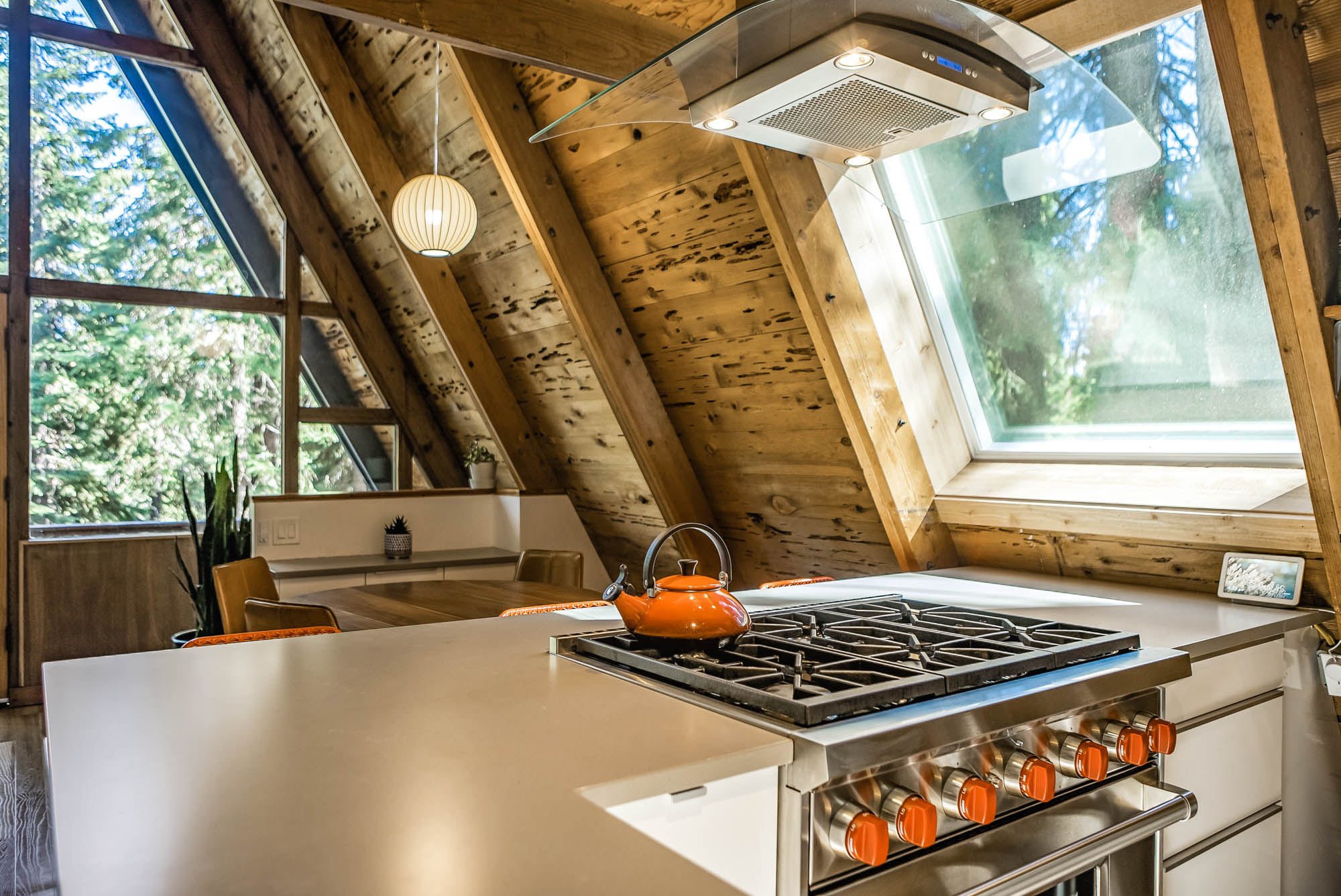 The gas range with an orange kettle and a snowy forest view